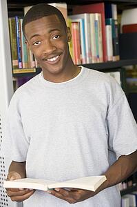 Man in library holding book