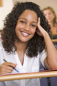 Student in class taking notes (selective focus)