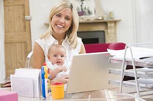 Mother and baby in home office with laptop