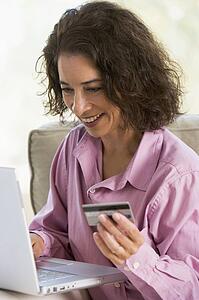 Woman with a laptop computer making an online purchase with credit card
