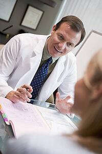 Doctor in consultation with woman at IVF clinic (selective focus)