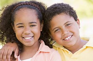 Brother and sister outdoors smiling