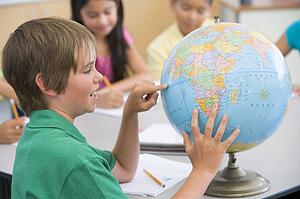 Student in class pointing at a globe (selective focus)