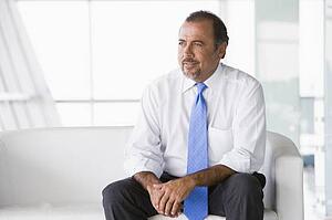 Businessman sitting indoors (high key/selective focus)