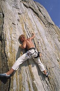 Free climber scaling cliff face