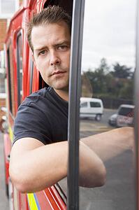 Fireman sitting in fire engine with head out window
