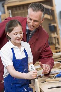 Female student learning woodworking