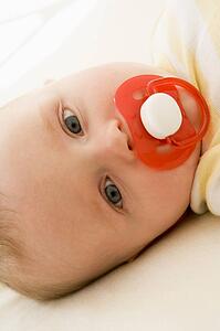 Baby lying indoors with soother