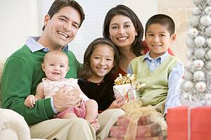 Family With New Born, Sitting On Sofa, Holding Christmas Gift