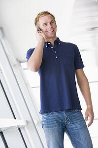 Man standing in corridor wearing headset smiling