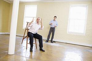 Two men with ladder in empty space making plans for room
