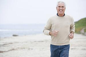 Man at the beach running and smiling