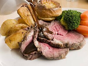Gravy being Poured on a plate of Roast Beef and Yorkshire Pudding