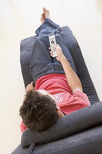 Man sitting in chair using remote control
