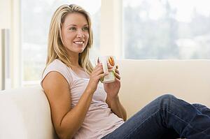Woman in living room with coffee smiling