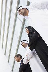 Four businesspeople standing outdoors by building (selective focus)