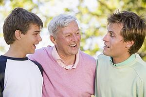 Grandfather with son and grandson smiling.