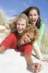 Three women posing on a sand hill