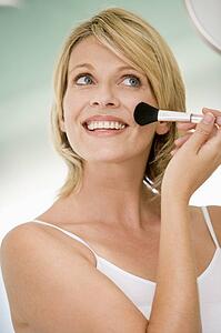 Woman with makeup brush smiling