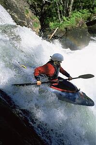 Kayaker in rapids going over waterfall (blur)