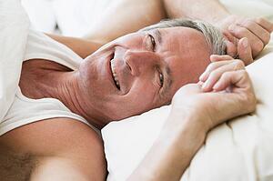 Man lying in bed smiling