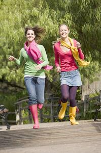 Pair Of Teenage Girls Jogging In Park 