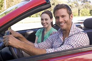 Couple in convertible car smiling
