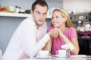 Young couple sitting at a table and having tea together