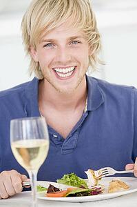 Young Man Enjoying meal, mealtime With A Glass Of Wine
