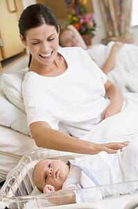 Pregnant mother with baby in hospital smiling
