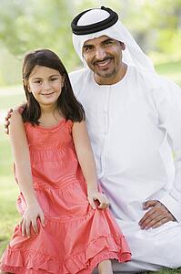 Man and young girl outdoors in a park smiling (selective focus)