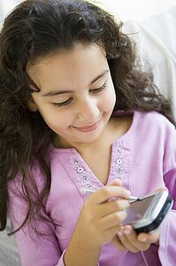 Young girl in living room with personal digital assistant smiling (high key/selective focus)