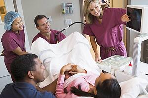 Doctor looking at monitor while retrieving eggs from ovary using vaginal ultrasound