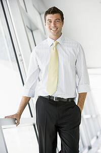 Businessman standing in corridor smiling