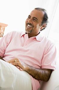 Man sitting in living room smiling (high key)