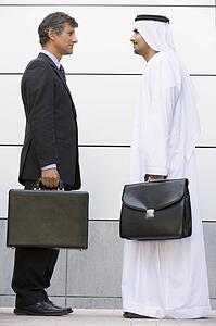 Two businessmen standing outdoors with briefcases