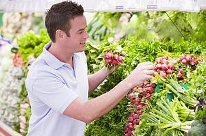 Man shopping for beets at a grocery store