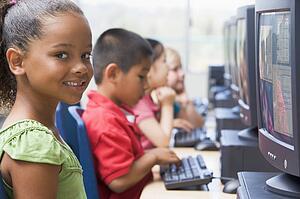 Four children at computer terminals (depth of field/high key)