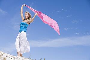 Young woman posing with a scarf on a beach