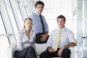 Three businesspeople sitting in office lobby