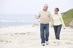 Couple at the beach holding hands and smiling