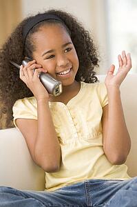 Young girl in living room using telephone and smiling