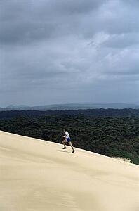 Man outdoors on sandy hill running