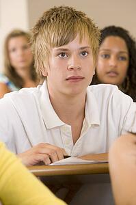 Student in class taking notes (selective focus)