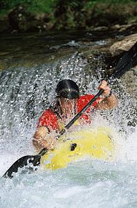 Kayaker coming down small waterfall (selective focus)