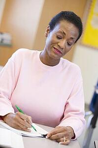 Adult student in class taking notes