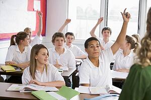 Secondary school students in a classroom answering questions