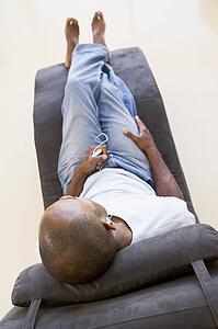 Man sitting in chair listening to MP3 player