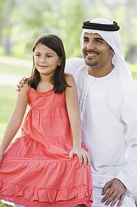 Man and young girl outdoors in a park smiling (selective focus)