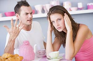 Young couple sitting at a table arguing